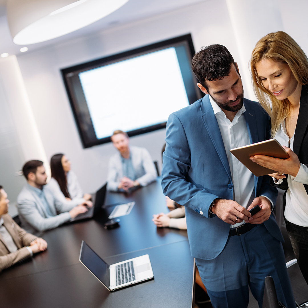 Businesspeople discussing while using digital tablet in office