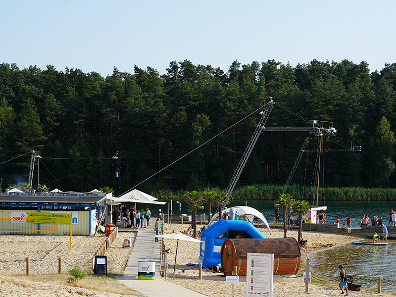 DOS Sommerfest 2024 am Bernsteinsee mit Blick auf die Wakeboardanlage und den Beachclub